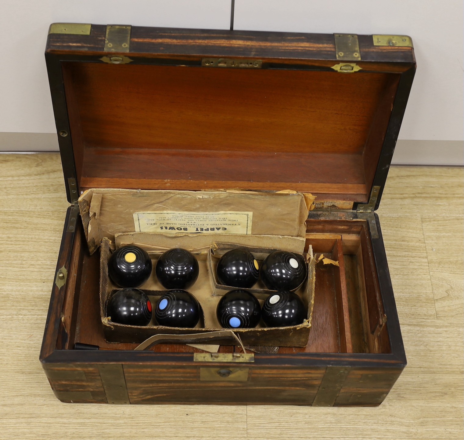 A boxed set of eight Banda carpet bowls, in a Victorian coromandel writing slope (a/f), 35cm wide